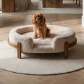 The Chic Henley Dog Bed in Sandstone, with a cavalier sitting in the nest