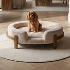 The Chic Henley Dog Bed in Sandstone, with a cavalier sitting in the nest