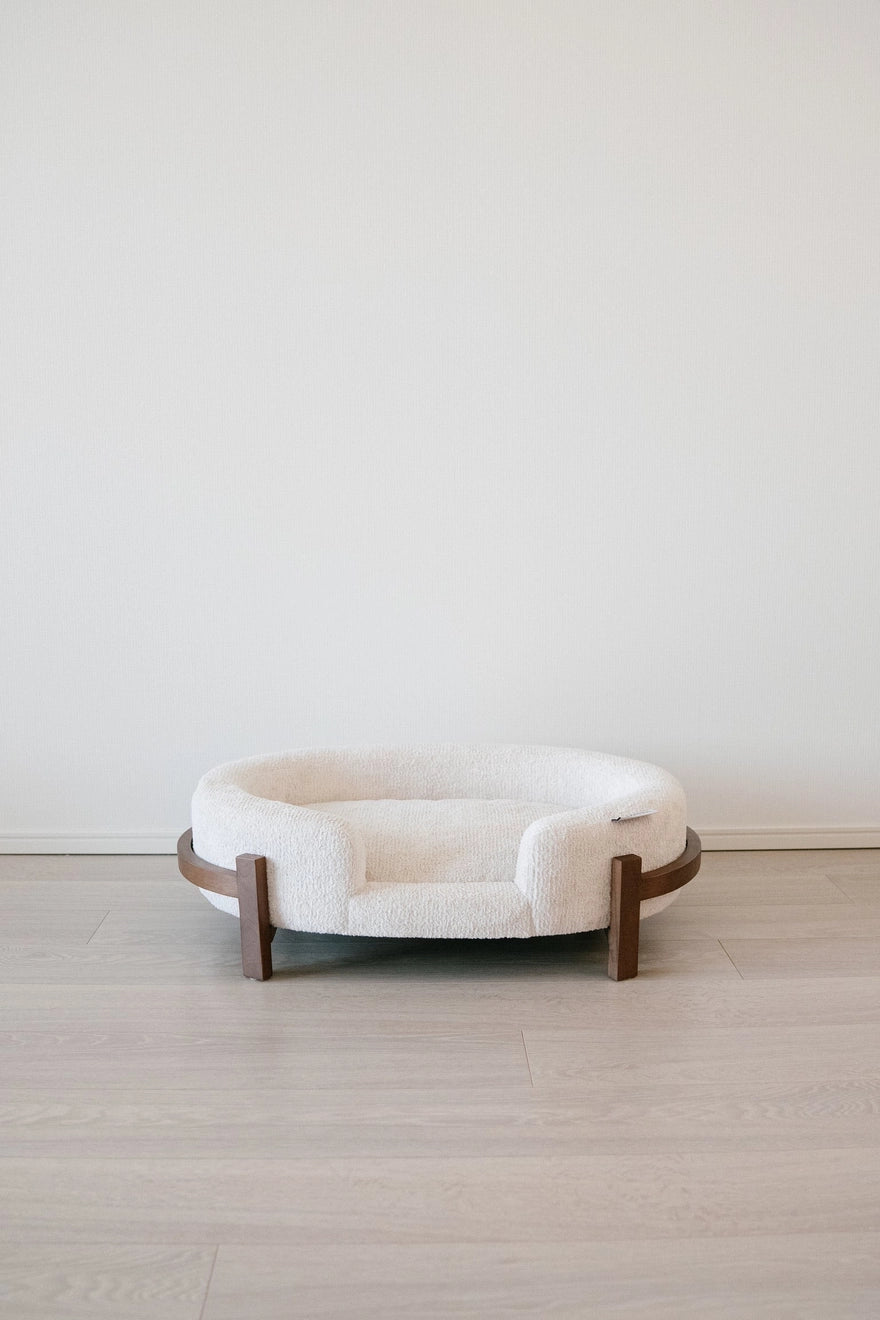 The Chic Henley Dog Bed in Sandstone, front view showing the low entry and the bolster walls