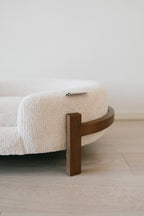 Close-up of the wooden leg and curved veneer band supporting the Sandstone cushion
